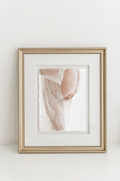 a beautiful gold frame with a maternity image of a belly draped in lace and soft natural light