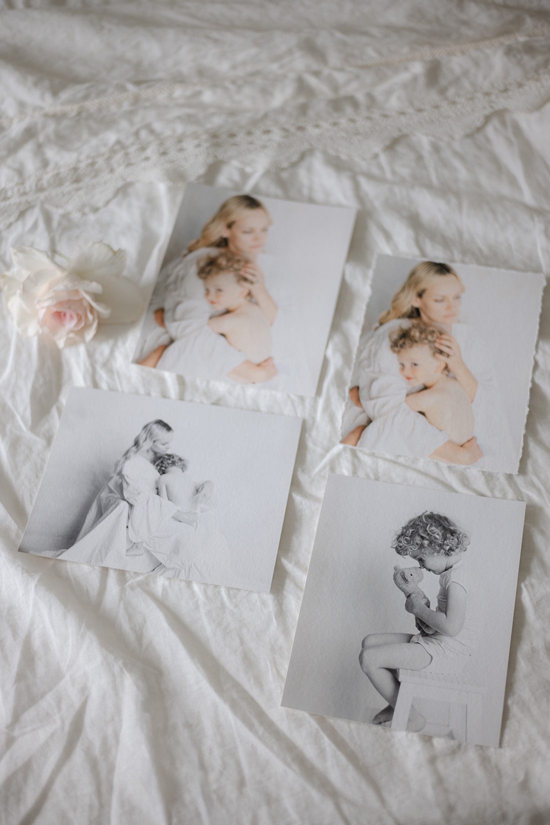 fine art prints of a mother and child laid out on ivory linen next to a rose